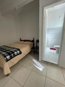 MatipóHotel Boa Vista的一间卧室配有一张床,浴室设有水槽