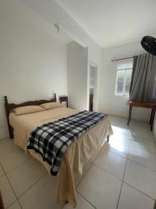 MatipóHotel Boa Vista的一间卧室配有一张带黑白毯子的床