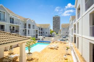 开普敦Tranquil Haven with Uninterrupted Power, a Serene Oasis in the Heart of Cape Town的一个带游泳池和建筑的公寓庭院