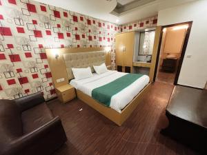 新德里Hotel Diamond Airport的一间卧室配有一张床、一把椅子和一张沙发