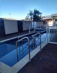 普雷图河畔圣若泽Apartamento para Negócios e Lazer no Aeroporto的一座带金属扶手的游泳池,位于一座建筑旁边