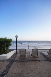 圣克鲁斯-德特内里费Playa Chica Beachfront Apartment的海滩旁的两把椅子和一盏灯