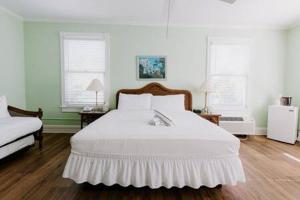 基韦斯特King Suite at Curry Mansion with Heated Pool by Brightwild!的卧室配有白色的床和2扇窗户。