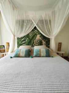 勒迪亚芒Ti Grounouy的一间卧室配有一张带天蓬的白色床