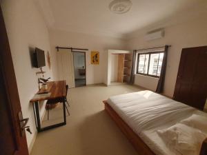 科托努Cocoon Guest House的一间卧室配有一张床和一张书桌