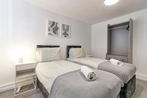NevendonNewly Refurbished 3BR House Basildon, Garden, Netflix & Trisport Table的白色墙壁客房的两张床