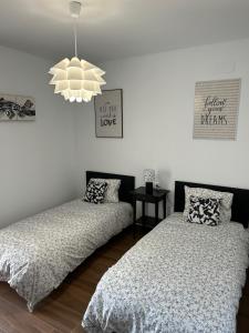 卡瓦内斯Casa Juan的一间卧室配有两张床和吊灯。