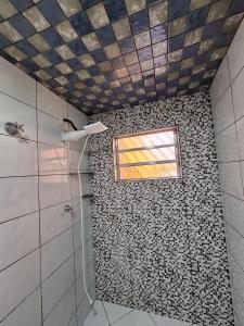 瓜鲁柳斯Hostel My House quartos perto do aeroporto de Guarulhos的一间带瓷砖淋浴和窗户的浴室