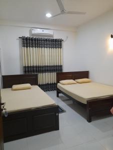 波隆纳鲁沃Hotel Sanhida Polonnaruwa的两张床位于带窗户的房间内