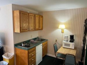 斯托斯托堆雪汽车旅馆的厨房配有水槽和带微波炉的桌子