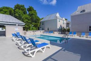 基韦斯特New Casa Caribe by Brightwild- Two-Story Condo Rooftop Pool的一个带躺椅的游泳池和一个游泳池