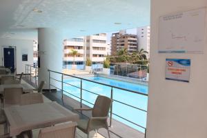 卡塔赫纳大西洋勒克斯酒店的阳台设有游泳池和桌椅。