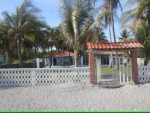 El PorvenirVistabella Beach House - Pool, Beach - 12ppl的海滩上的房子,有围栏和棕榈树