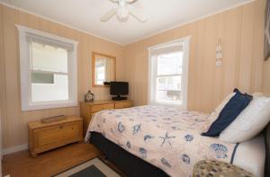 蒙托克The Montauk Soundview的一间卧室设有一张床、一台电视和两个窗户。