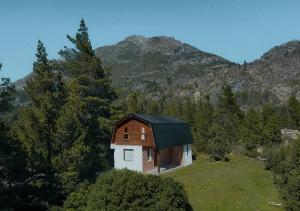 埃普延Los Cauces - Reserva Cannábica的山丘上的小房子,背景是群山