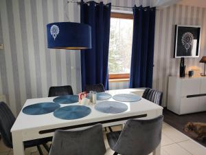 拉伊恰Villove Domy Spa的一张带椅子和蓝灯的餐桌