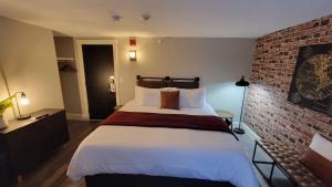 吉尔福特Gunstock Inn & Suites的一间卧室设有一张带砖墙的大床