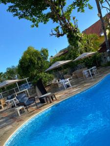 璜多里奥迪芙兰切斯旅馆的毗邻度假酒店的带椅子和遮阳伞的游泳池