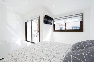 圣胡安海滩Aqua Viva - Playa San Juan的一间白色卧室,配有床和2个窗户