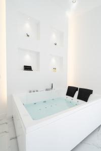 圣胡安海滩Aqua Viva - Playa San Juan的白色客房内的浴缸配有两把椅子