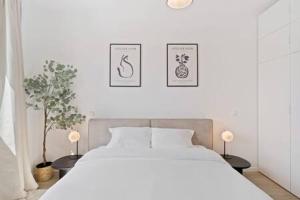 勒瑟Stylish Retreat in Bivange Roeser的卧室配有白色的床和墙上的两张照片