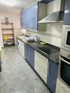 卡拉德莫尔Apartamento La cala 2的厨房配有蓝色橱柜、水槽和洗碗机。