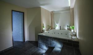 麦德林HOTEL BALI AT POBLADO的一间带浴缸和大镜子的浴室