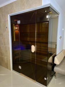 哈尔科夫Spa-отель的一个带椅子的玻璃淋浴间