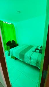 塔克纳Apartamento/Departamento independiente nuevo的一间卧室配有一张蓝色和绿色的灯光床