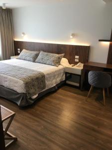 伊瓦拉Hotel Ajavi的一间卧室配有一张床、一张书桌和一张书桌