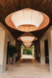 帕洛米诺Naio Hotel y Villas的走廊设有大型木制天花板和大型灯具