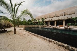帕洛米诺Naio Hotel y Villas的一个带游泳池和棕榈树的度假村