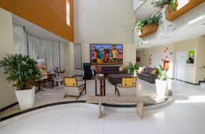 阿拉卡茹三德林普拉亚酒店的大堂设有带沙发和植物的客厅