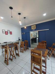 库亚巴Hotel Perola Ltda的餐厅设有木桌和椅子,拥有蓝色的墙壁