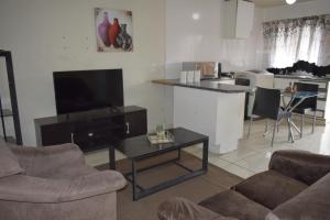 杰米斯顿Apartment in Germiston (Johannesburg)的带沙发、电视和桌子的客厅