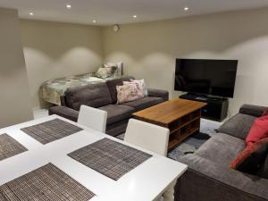默恩达尔90 m2 charmig källarlägenhet nära natur och stad的客厅配有沙发和桌子