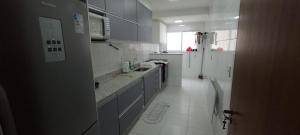 大普拉亚Apartamento Encantador的厨房配有蓝色橱柜和白色瓷砖地板。