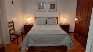 阿马多拉Judith House - Amadora Este的一间卧室配有一张带两盏灯和一把椅子的床。