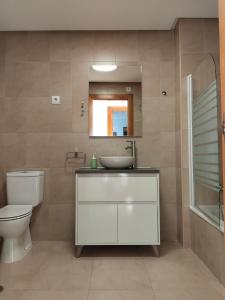 托雷帕切科Apartamento La Torre Golf的一间带水槽、卫生间和镜子的浴室