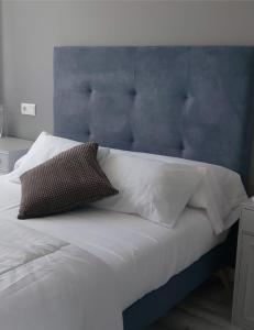 蓬费拉达El Silencio de Galadhrim的一张带蓝色床头板和白色枕头的床