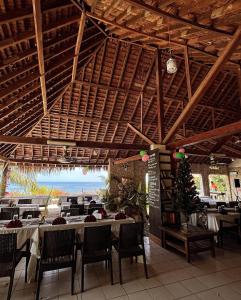 塔纳岛塔纳常青旅游度假村的一间带桌椅的海景餐厅