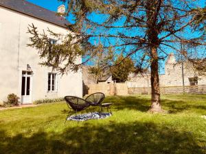 Monceaux-en-BessinMaison au cœur d'une ancienne ferme à BAYEUX的坐在树旁的草上椅子