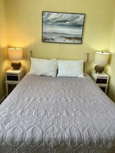 阿兰瑟斯港Seashell Village Resort near the beach with kitchens的一间卧室配有一张床、两个床头柜和两盏灯。