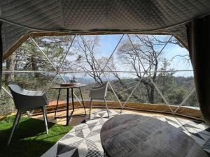 DunlapGlamping Dome 1 - 10 minutes from Kings Canyon的客房设有桌椅和大窗户。