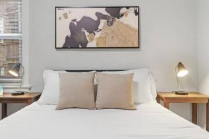 芝加哥Elegant & Stylishly 1BR Fully Furnished Apt - Lincoln 205的一间卧室配有一张带白色床单和两盏灯的床。