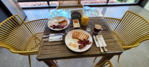 SabogaHOSTAL LOS CEDROS的一张桌子,上面放着两盘早餐食品和一瓶橙汁