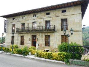 Ontaneda波萨达德尔帕斯酒店的一座带窗户和阳台的石头建筑