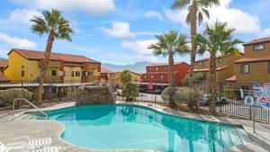 梅斯基特Golfer’s Oasis Condominium at Hawk Ridge的一座棕榈树和建筑游泳池