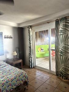 IztapaCasa de playa, en isla, frente al mar y canal的卧室设有滑动玻璃门,可通往庭院。