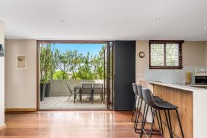 拜伦湾Byron Bay Accom Unit 6 21-25 Fletcher Street - A Seventh Heaven的开放式厨房以及带桌椅的用餐室。